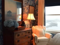 Exterior view of the Gracious Farmhouse showcasing rustic architecture and lush surroundings.